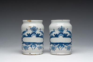 Three Dutch Delft blue and white dishes with a bird and floral design and two pharmacy jars, 18th C.
