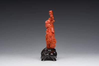 A Chinese red coral group with the 'Star God' Shou Xing and a lady, 19th/20th C.