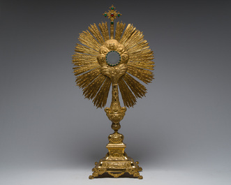 A large French gilt bronze monstrance decorated with cherubs amidst radiant clouds and set with glass stones, ca. 1900