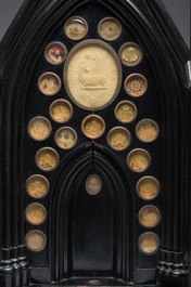 A large French Gothic Revival ebonized wooden cathedral-shaped reliquary with various relics, last quarter 19th C.