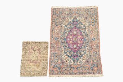 A Persian Kerman (Kirman) rug with figurative design and an Isfahan rug with floral design, wool on cotton, 20th C.