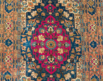 A Persian Kerman (Kirman) rug with figurative design and an Isfahan rug with floral design, wool on cotton, 20th C.