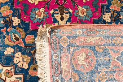 A Persian Kerman (Kirman) rug with figurative design and an Isfahan rug with floral design, wool on cotton, 20th C.
