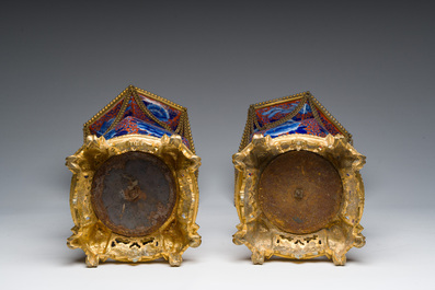 A Japanese polychrome three-piece garniture with ladies in a landscape mounted into a clock with richly gilt bronze mounts, 19th C.