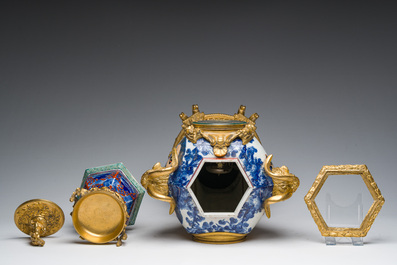 A Japanese polychrome three-piece garniture with ladies in a landscape mounted into a clock with richly gilt bronze mounts, 19th C.
