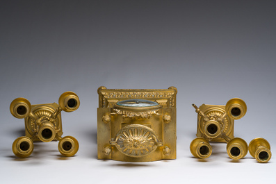 A French Louis XVI style gilt bronze and cut glass mantel clock accompanied by a pair of candlesticks, 19th/20th C.