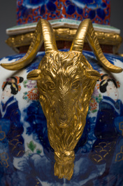 A Japanese polychrome three-piece garniture with ladies in a landscape mounted into a clock with richly gilt bronze mounts, 19th C.