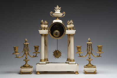 A French Louis XVI style three-piece gilt bronze mounted white marble clock garniture crowned with a flower basket, 19th C.
