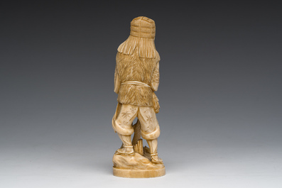 A Japanese ivory okimono of a hunter with his hunting trophy, signed, Meiji, ca. 1900