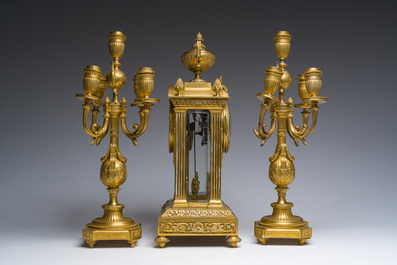 A French Louis XVI style gilt bronze and cut glass mantel clock accompanied by a pair of candlesticks, 19th/20th C.