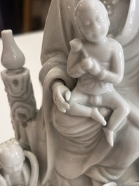 A Chinese Dehua blanc de Chine figure of Guanyin with servants, 19th C.