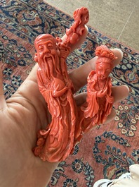 A Chinese red coral group with the 'Star God' Shou Xing and a lady, 19th/20th C.