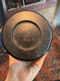 A Chinese ebonized wooden brush pot with relief design of lotus flowers and an inscription, 20th C.