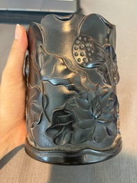 A Chinese ebonized wooden brush pot with relief design of lotus flowers and an inscription, 20th C.
