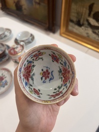 Six Chinese famille rose and gilt cups and saucers and a cream jug with floral and mandarin design, Yongzheng/Qianlong