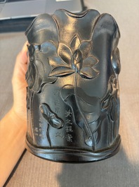 A Chinese ebonized wooden brush pot with relief design of lotus flowers and an inscription, 20th C.