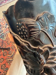 A Chinese ebonized wooden brush pot with relief design of lotus flowers and an inscription, 20th C.