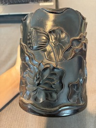 A Chinese ebonized wooden brush pot with relief design of lotus flowers and an inscription, 20th C.