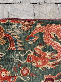 A Tibetan wool 'dragons and phoenixes' rug, 19th C.
