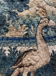 A Flemish wall tapestry with birds in a landscape with a castle in the background, 17th C.