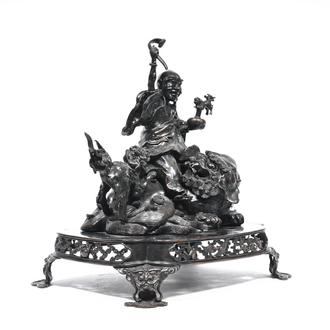 A large Japanese patinated bronze group of an Immortal with two Shishi on an open worked base, Meiji, 19th/20th C.