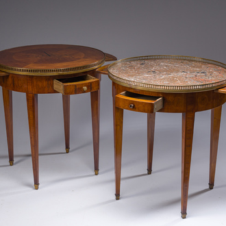 Two French Louis XVI style marquetry bouillotte tables with a brass gallery, one with a wooden and one with a marble top, 19th C.