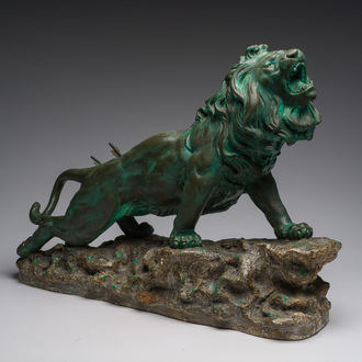 Belgian school, Van den Balck (19th/20th C.): A roaring lion on a rock struck by arrows, green and gray patinated plaster, Brussels