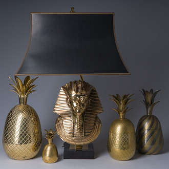 A Hollywood Regency gilt brass 'pharaon' table lamp, Deknudt, Kortrijk, and four Hollywood Regency style pineapples, 20th C.