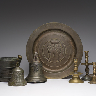 Two bells, a mortar and stamper, three candlesticks and an alms dish in bronze and brass, 17th/19th C.