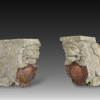 A pair of partly polychromed stone beam supports in the shape of lions holding coats of arms, probably Flanders, 16th/17th C.
