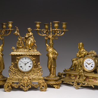 Two gilt bronze mantel clocks and a pair of four-light caryatid-shaped candlesticks, France and Germany, 19th/20th C.