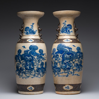 A pair of Chinese Nanking crackle glazed blue and white vases with Buddhist lions and birds among blossoming branches, 19th C.