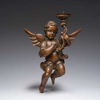 A French carved wooden one-light wall candlestick in the shape of a putto with a torch in his hand, 18th C.