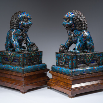 A pair of Chinese cloisonné Buddhist lions on a wooden base, 20th C.