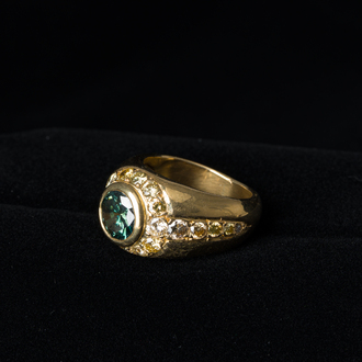 An 18 carat yellow gold men's ring with a central green-blue diamand of 1,98 carats and finished with various other diamonds, 20th C.