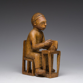 Sculpture en bois sculpté d'un homme assis à un bureau avec un livre à la main, Bakongo, Congo, premier tiers du 20ème siècle