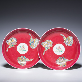 A pair of Chinese famille rose saucers with butterflies on a ruby red ground, 19th/20th C.