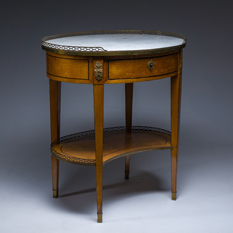 An oval French Louis XVI wooden writing table with gilt copper and brass mounts and a marble top, circa 1800