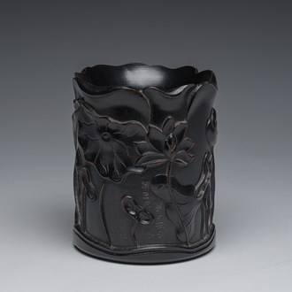 A Chinese ebonized wooden brush pot with relief design of lotus flowers and an inscription, 20th C.