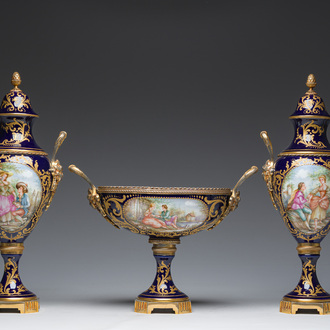 A French gilt bronze mounted blue ground Sèvres style three-piece garniture with gallant scenes, 20th C.