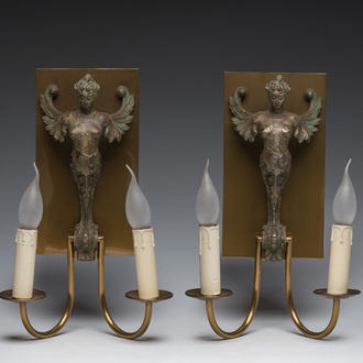 A pair of two-light wall lights in the shape of winged caryatids in patinated cast iron and brass, 20th C.