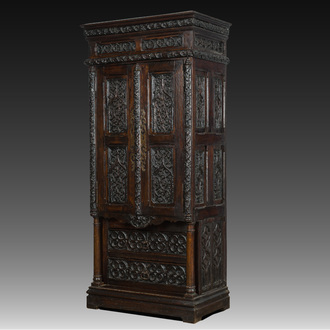 A French Gothic Revival carved wooden cabinet with two doors and two drawers with a fleur-de-lis design, 19th C.