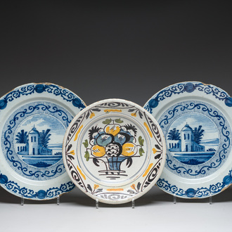 A pair of Dutch Delft blue and white dishes with a building in a landscape and a polychrome plate with a fruit basket, 18th/19th c.