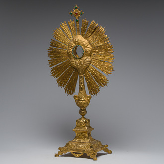 A large French gilt bronze monstrance decorated with cherubs amidst radiant clouds and set with glass stones, ca. 1900