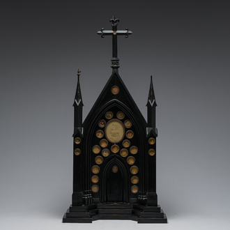 A large French Gothic Revival ebonized wooden cathedral-shaped reliquary with various relics, last quarter 19th C.