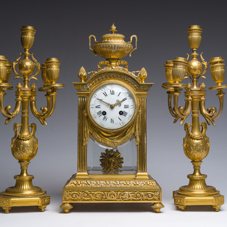 A French Louis XVI style gilt bronze and cut glass mantel clock accompanied by a pair of candlesticks, 19th/20th C.