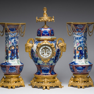 A Japanese polychrome three-piece garniture with ladies in a landscape mounted into a clock with richly gilt bronze mounts, 19th C.