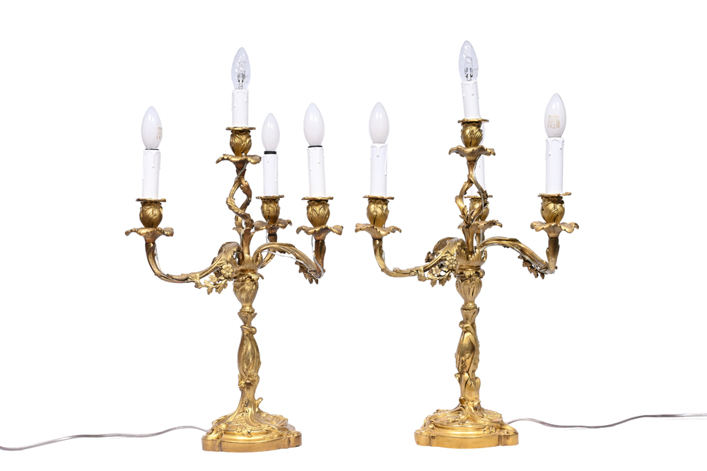 A pair of French Louis XV style gilt bronze four-light candlesticks with floral relief design, 19th/20th C.