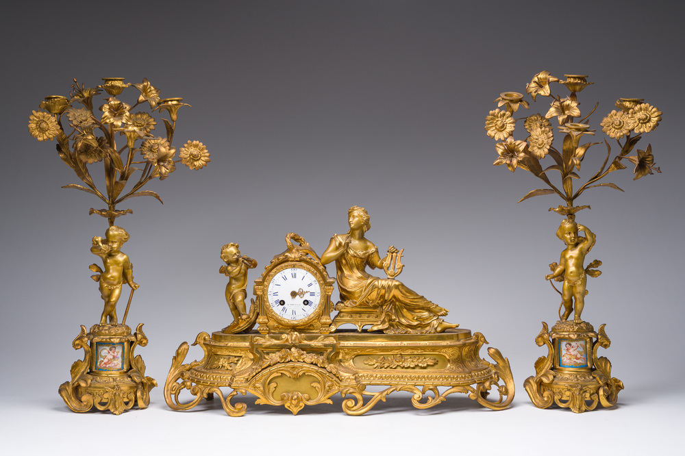 A French gilt bronze three-piece clock garniture with Erato, playful putti and S&egrave;vres style plaques, 19th C.