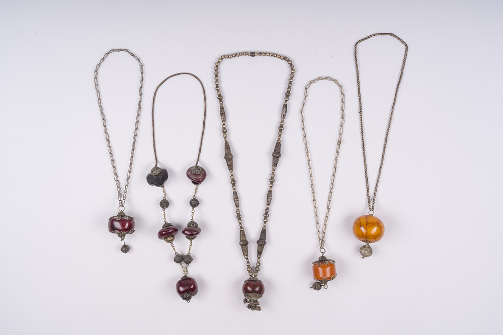 Five silver and copper necklaces with amber pendants, Morocco and Nepal, 19th/20th C.